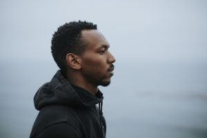 black man on beach thinking